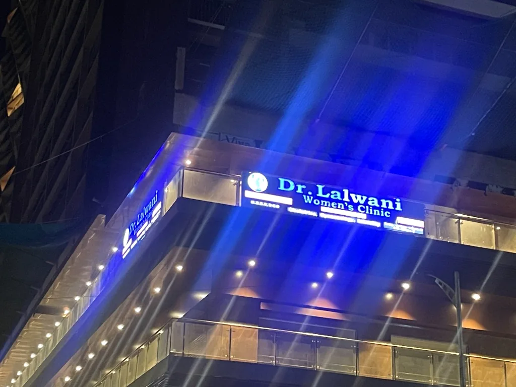 The Collection by Brahma Corp Building Facade with Illuminated Signage at Night